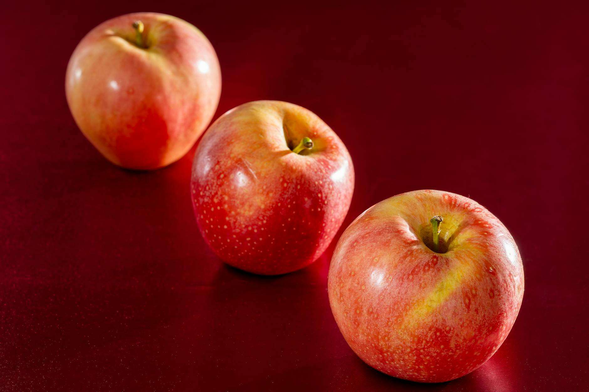 fresh red apples on a vibrant red background